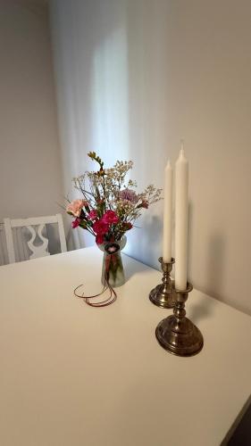 a table with two candles and a vase of flowers at Villa South Beach in Karlskrona