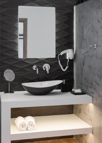 a bathroom with a sink and a mirror at Sette Suites & Rooms - Adults Only in Xylokastron