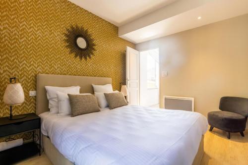 une chambre avec un grand lit blanc et une chaise dans l'établissement T3 Moderne au coeur de Castanet-Tolosan, à Castanet-Tolosan