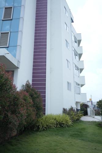a tall white building with stairs on the side of it at Kalgadde in Chikmagalūr