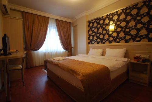 a bedroom with a bed and a desk and a window at Mini Hotel in Izmir