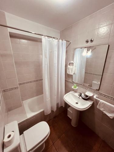 a bathroom with a toilet and a sink and a tub at Fogar dos Antigos in Mazaricos