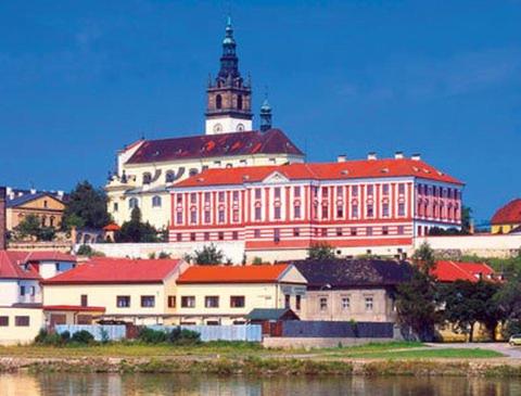 a large building with a clock tower on top of it at Chaloupka u Lovoše in Velemín