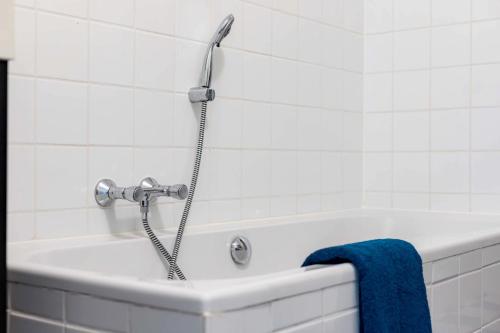 a bath tub with a shower head in a bathroom at Appartement La Costa - Gasselte in Gasselte