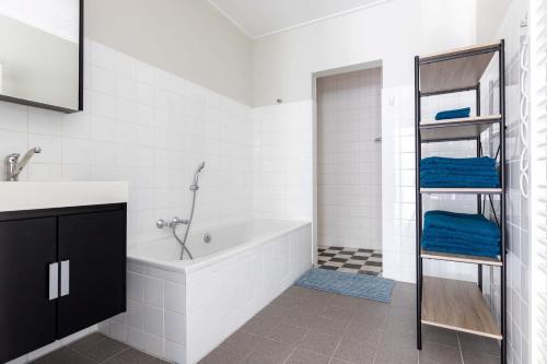 a white bathroom with a tub and a sink at Appartement La Costa - Gasselte in Gasselte