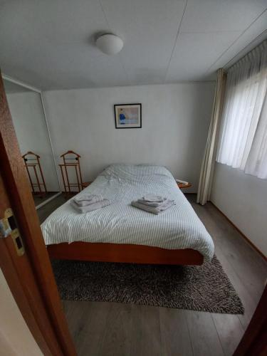 a bedroom with a bed and two chairs in it at Chalet "Uit Zicht" in Putten