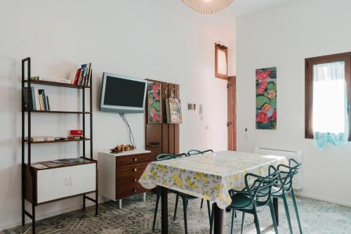 a dining room with a table with chairs and a tv at La Vanedda in Partanna