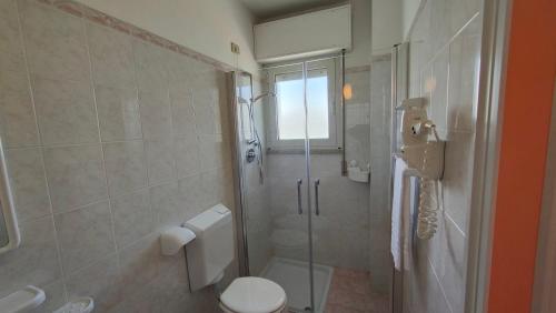 a bathroom with a toilet and a glass shower at Hotel Capri in Grado