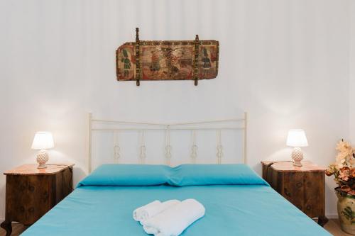 a bedroom with a blue bed with towels on it at La Vanedda in Partanna