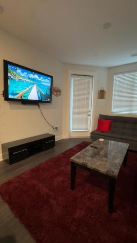 a living room with a flat screen tv on the wall at The 513 Flat-1BR, 1 Bath Apmt with Pool and Riverfront View Only Steps from The banks & Stadiums in Cincinnati
