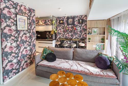 - un salon avec un canapé et un mur fleuri dans l'établissement Coeur Marina Baie des Anges, between Nice and Cannes, à Villeneuve-Loubet