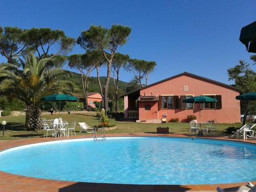 a large swimming pool in front of a house at Agriturismo Debbione Marconi in Suvereto