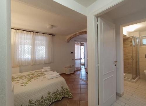a bedroom with a bed and a door to a bathroom at Mirto E Mare in Muravera