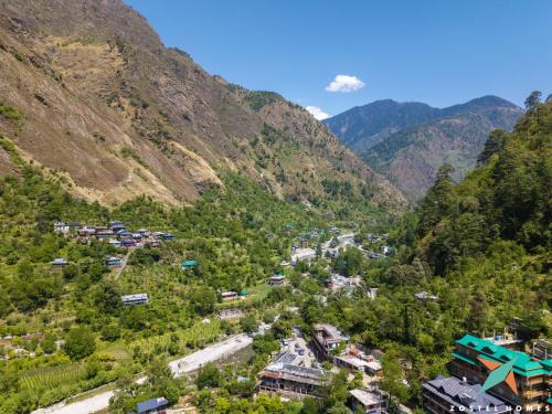 a village in a valley in the mountains at Zostel Homes Tirthan, Gushaini in Gushaini