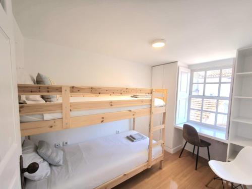 a room with two bunk beds and a desk at Casa do Beco - Foz do Douro in Porto