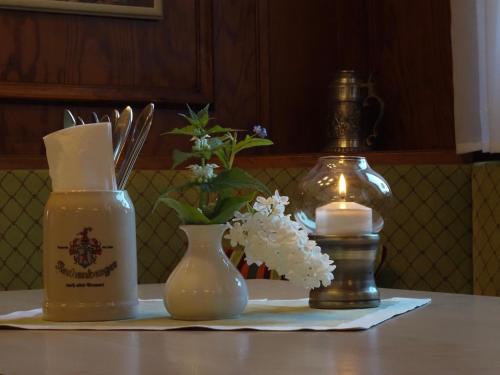a table with a bottle of soap and a vase with flowers at Gasthof Hillig in Bad Gottleuba