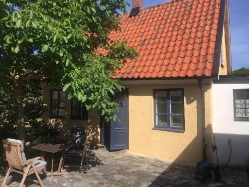 a house with an orange roof and a table and chairs at Beautiful Home In Simrishamn With 2 Bedrooms And Wifi in Simrishamn
