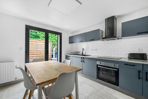 Il comprend une cuisine avec une table et des chaises en bois. dans l'établissement Le Jardin - 3 pièce - Parking - Disney & Paris, à Le Plessis-Trévise