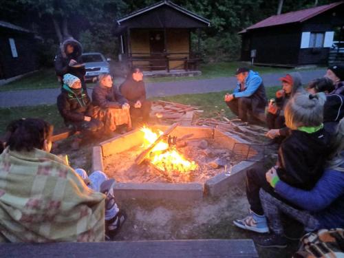 a group of people sitting around a fire at ATC Kemp Kajlovec in Hradec nad Moravici