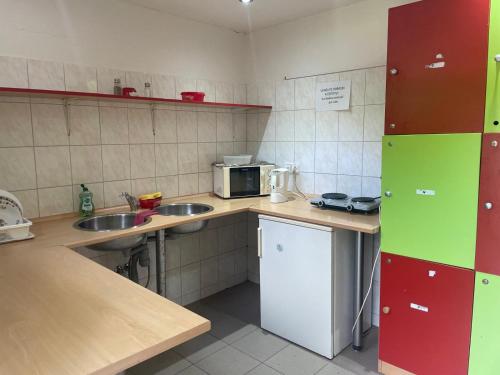 a small kitchen with two sinks and a microwave at ATC Kemp Kajlovec in Hradec nad Moravici