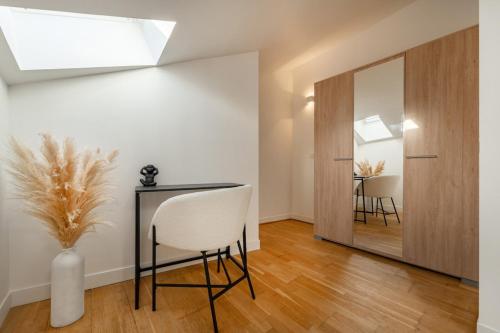 a room with a table and a chair and a mirror at Le Petit Saint Martin - Duplex - Cœur de ville in Soissons