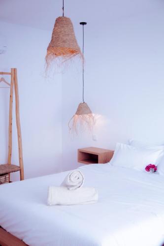 a bedroom with a white bed with two towels on it at Mar-Ria 5 in Fuzeta