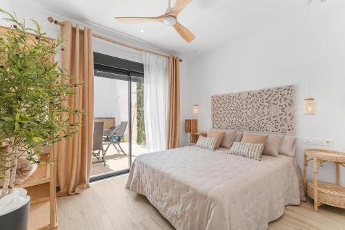 a white bedroom with a bed and a balcony at Casa Catral Alfalfar 12 in Catral