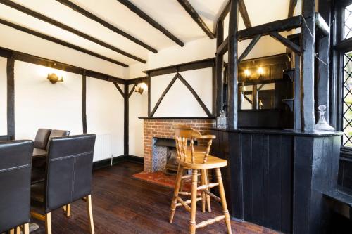 a room with a table and chairs and a fireplace at Lux 8Br Thamesfront Villa w Yacht & Sauna in Staines