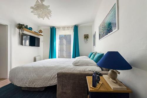 - une chambre avec un lit doté d'une lampe bleue sur une table dans l'établissement Ohana, à Deauville