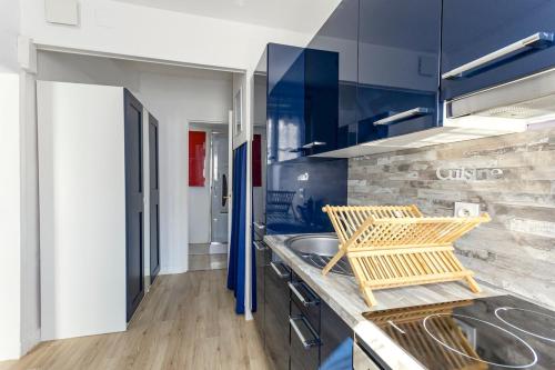 - une cuisine avec un évier et 2 chaises dans l'établissement Ohana, à Deauville