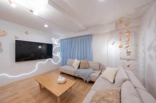 a living room with a couch and a tv at Liminal Retreats NAGOYA in Nagoya