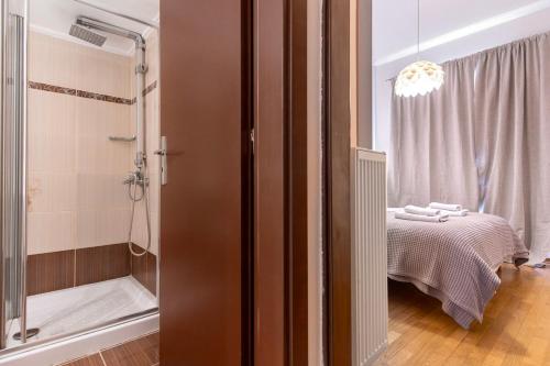 a bathroom with a shower and a bed and a tub at Stylish 2BDR Exarchia Apt with Balcony and Workspace in Athens