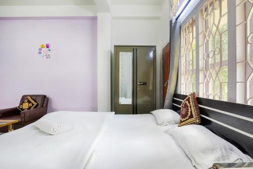 a bedroom with a large bed with white sheets and pillows at GREEN VISTA HOMESTAY in Guwahati