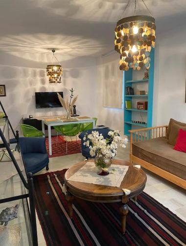 a living room with a table and a couch at Des appartements a la Marsa plage Pieds dans l'eau in Dar Salah Bey