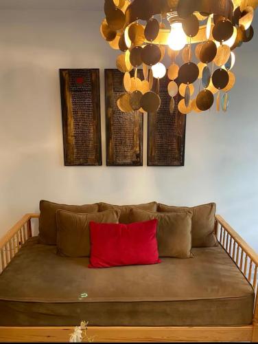 a couch with a red pillow in a room at Des appartements a la Marsa plage Pieds dans l'eau in Dar Salah Bey