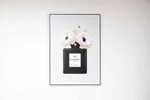 a picture of a black bottle with a flower in it at MOLA Apartments-Moderne Ferienwohnung im Herdecker Zentrum für 3 Personen-mit Balkon-Grill-Gratis Parkplatz-WLAN in Herdecke