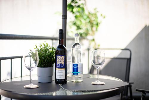 a bottle of wine and two wine glasses on a table at MOLA Apartments-Moderne Ferienwohnung im Herdecker Zentrum für 3 Personen-mit Balkon-Grill-Gratis Parkplatz-WLAN in Herdecke