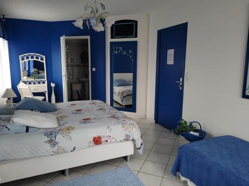 a bedroom with blue walls and a bed and a mirror at Haubette in Meurville