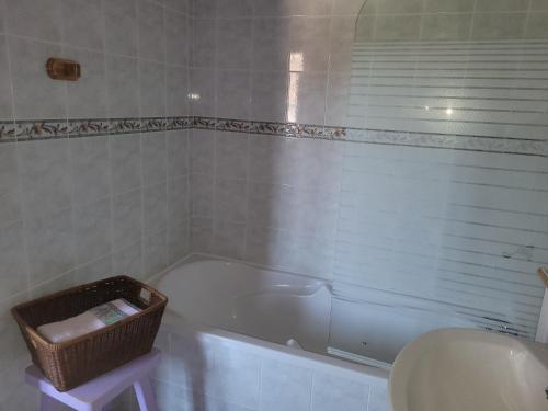 a bathroom with a white tub and a basket next to a sink at Haubette in Meurville