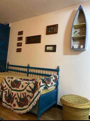 a bedroom with a bed with a blanket on it at Des appartements a la Marsa plage Pieds dans l'eau in Dar Salah Bey
