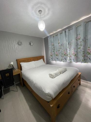 a bedroom with a bed and a window with curtains at Chic 2 Bed Apartment with Free Parking- Recently Redecorated, 10 Minutes to City Centre in Edinburgh