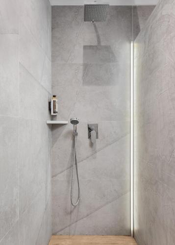 a bathroom with a shower with a shower head at Sette Suites & Rooms - Adults Only in Xylokastron