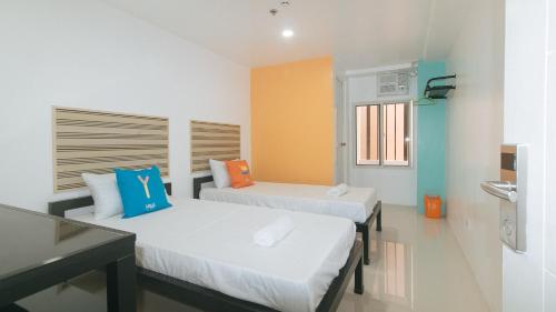 a room with two beds in a room at Sans Hotel near Enchanted Kingdom Santa Rosa Laguna in Santa Rosa