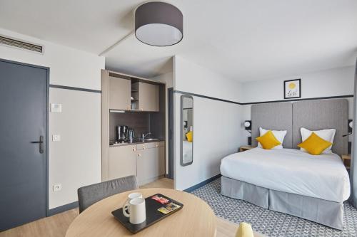 a hotel room with a bed and a table at Appart Hotel Odalys City Aix en Provence Les Floridianes in Aix-en-Provence