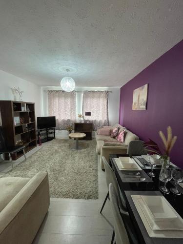 a living room with purple walls and a couch at Chic 2 Bed Apartment with Free Parking- Recently Redecorated, 10 Minutes to City Centre in Edinburgh