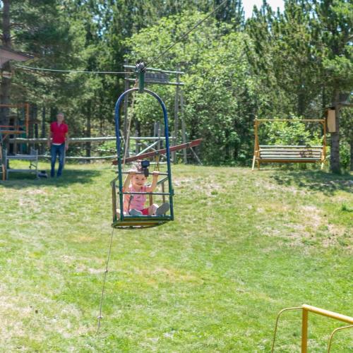 a little girl riding on a swing in a park at Vikendica Blidinje, Ranch Mikulic in Blidinje