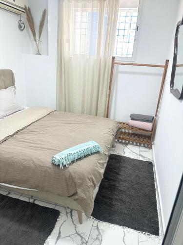a small bedroom with a bed and a window at Des appartements a la Marsa plage Pieds dans l'eau in Dar Salah Bey
