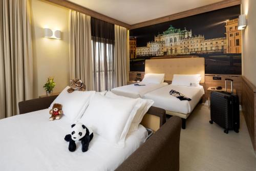 a hotel room with two beds with stuffed animals on them at Best Western Hotel Luxor in Turin