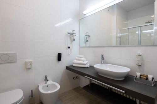 a white bathroom with a sink and a toilet at Best Western Hotel Luxor in Turin