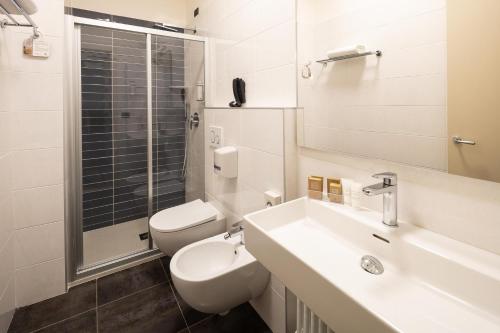 a white bathroom with a sink and a toilet at Best Western Hotel Luxor in Turin